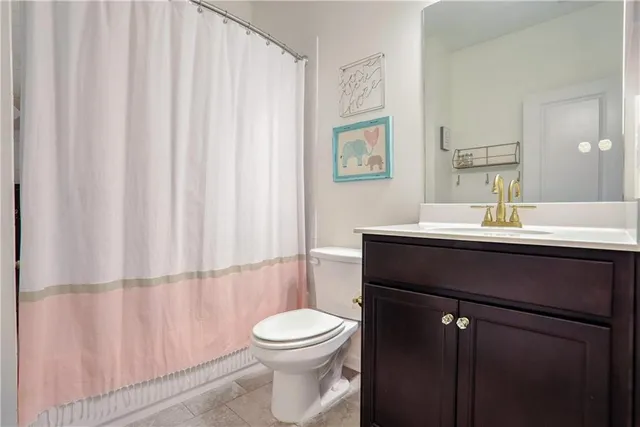 a bathroom with a sink a toilet and shower curtain