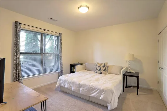 a bedroom with a bed and a lamp next to a window