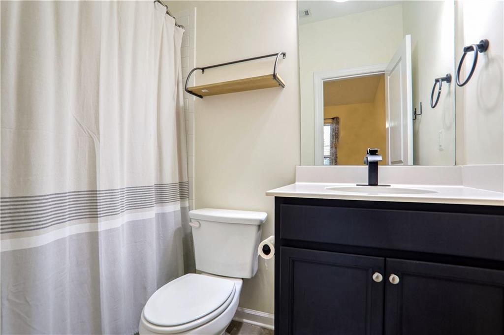 3216 Creole Lane Decatur, GA 30032 - Photo 20 of 25 a bathroom with a sink a toilet a mirror and shower curtain