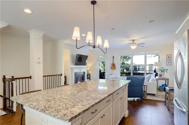 a kitchen with stainless steel appliances granite countertop a stove oven and a dining table with wooden floor