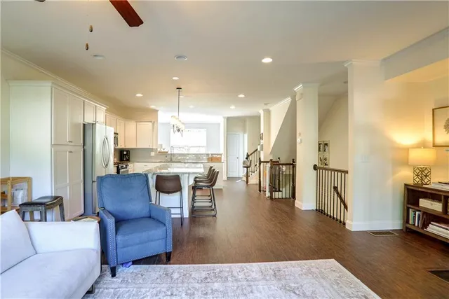 a living room with stainless steel appliances furniture refrigerator and a view of kitchen