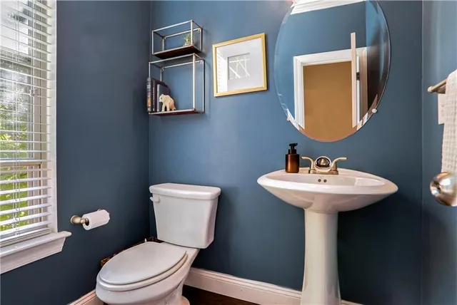 a bathroom with a toilet sink and mirror