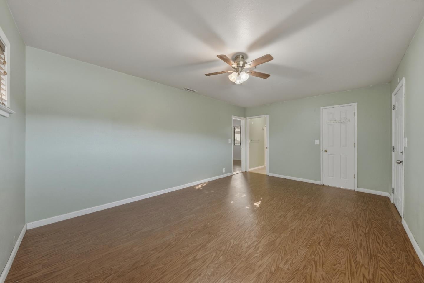 13590 Fair Oak Road Clearlake, CA 95422 - Photo 10 of 27 a view of an empty room with chandelier fan and wooden floor