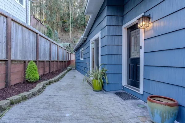 a backyard of a house with chairs and plants