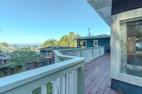 a view of a balcony with furniture and wooden floor