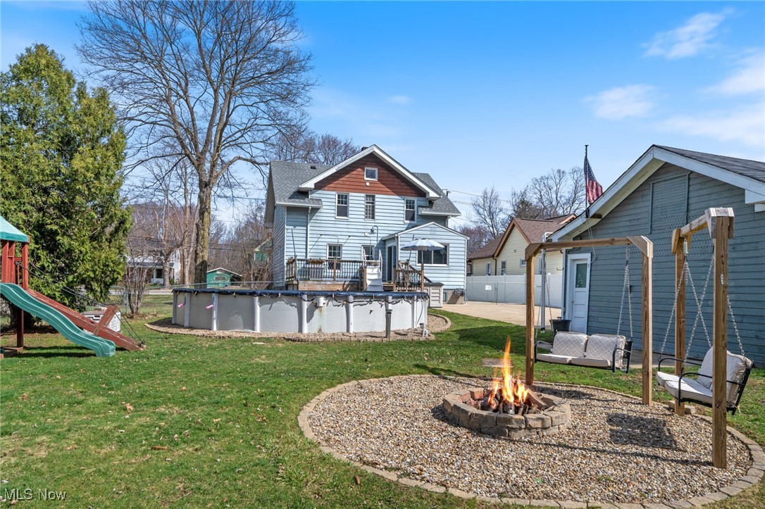 26903 Butternut Ridge Road North Olmsted, OH 44070 - Photo 28 of 37 Rear view of property with a covered pool, fence, a playground, a fire pit, and a lawn