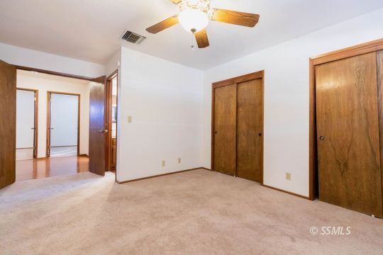 321 South Locust Street Ridgecrest, CA 93555 - Photo 17 of 30 an empty room with closet and a chandelier fan
