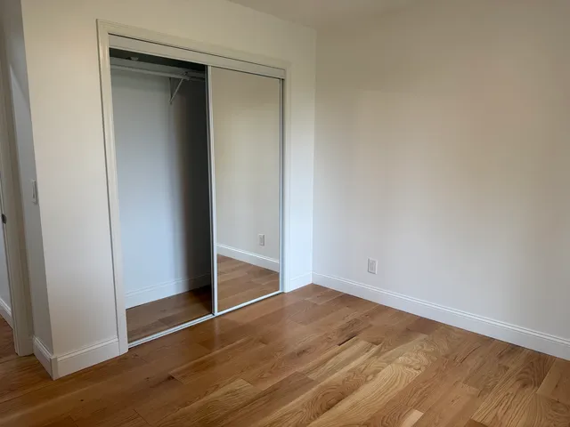 an empty room with wooden floor and closet