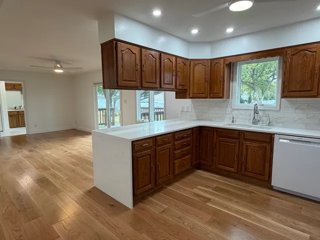 a kitchen with stainless steel appliances granite countertop wooden cabinets a oven and granite counter tops with a large window