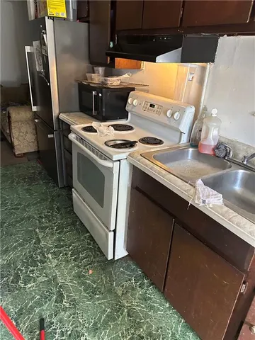 a stove top oven sitting inside of a kitchen