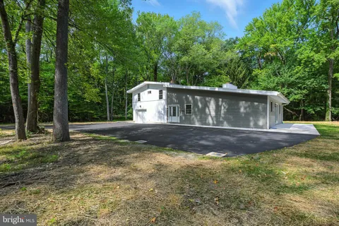 a view of a house with backyard and trees