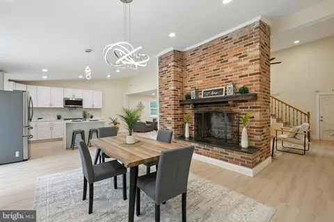 a view of a dining room with furniture wooden floor and a fireplace