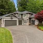 a front view of a house with a garden and yard