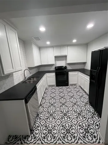 a large kitchen with a sink and stainless steel appliances