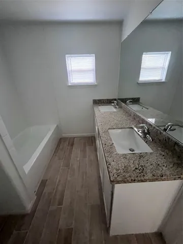 a bathroom with a tub sink and vanity