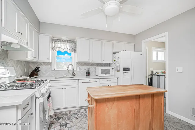 a kitchen that has a lot of cabinets in it and appliances