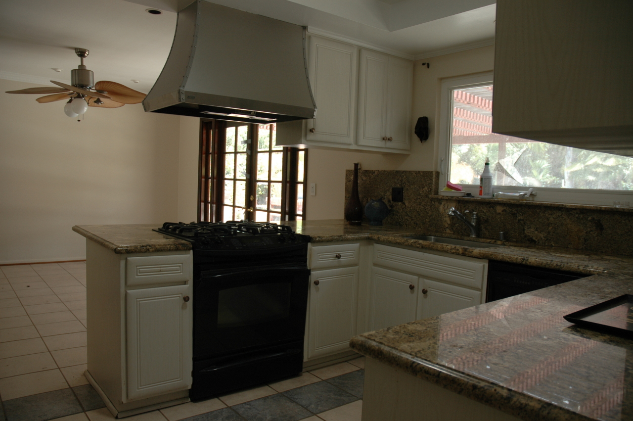 224 Serpolla Drive Carpinteria, CA 93013 - Photo 3 of 11 a kitchen with granite countertop a stove and white cabinets