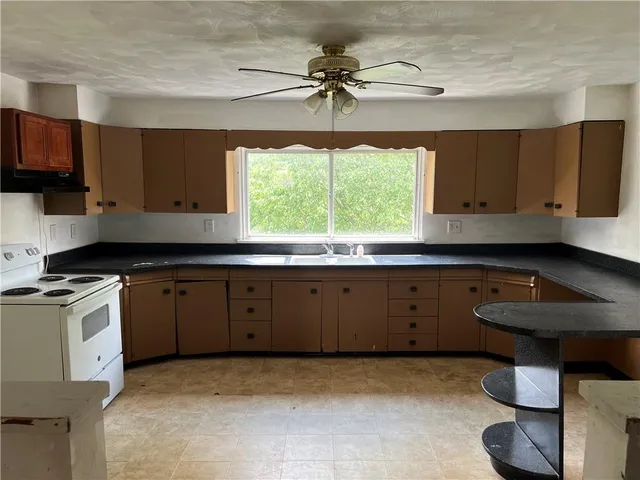 a kitchen with a stove a sink and a window