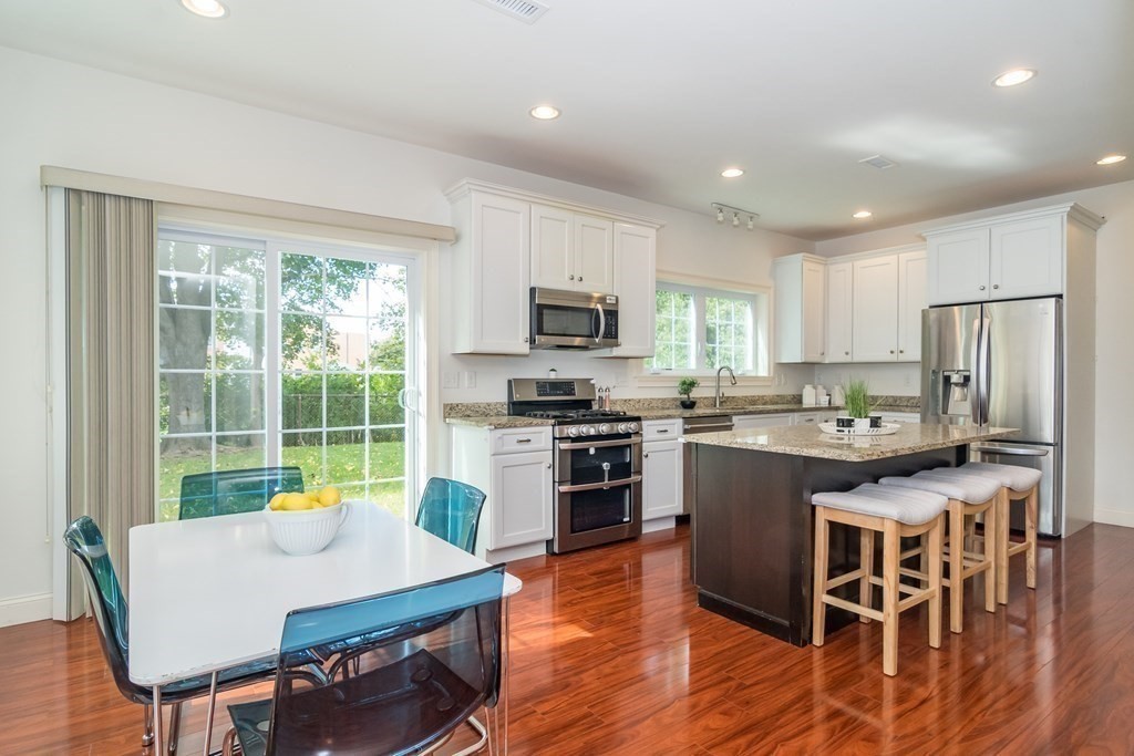 10 Farrant Road Natick, MA 01760 - Photo 11 of 31 a kitchen with stainless steel appliances granite countertop a stove top oven a sink dishwasher a dining table and chairs with wooden floor