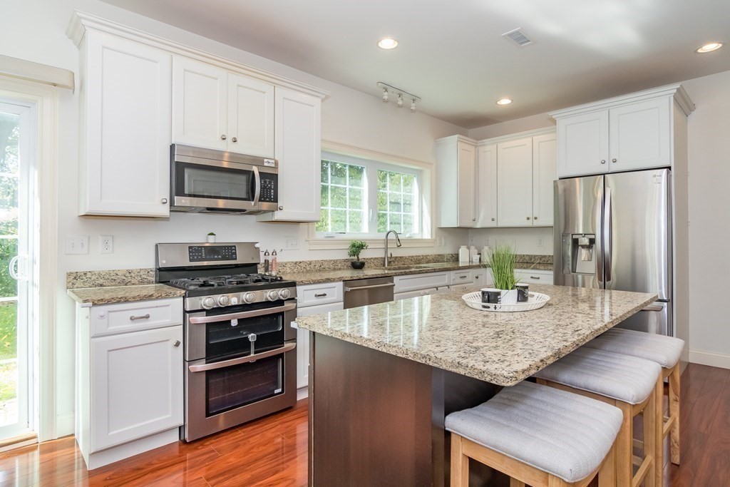 10 Farrant Road Natick, MA 01760 - Photo 9 of 31 a kitchen with stainless steel appliances granite countertop a stove a sink a microwave a refrigerator and white cabinets