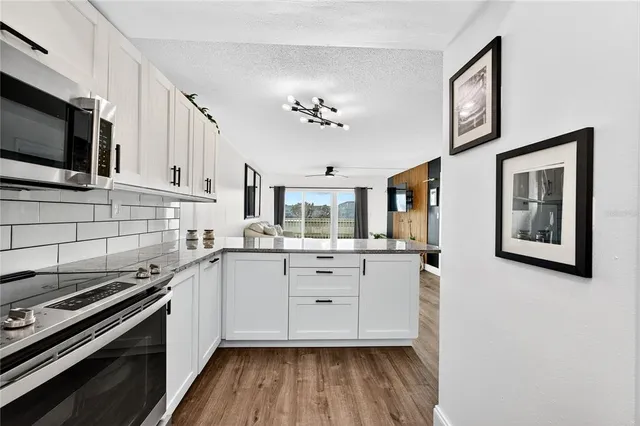 a kitchen with granite countertop a stove a sink and a microwave