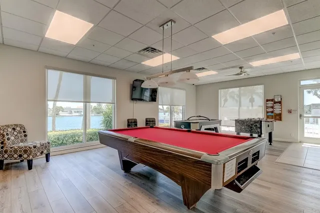 a room with pool table and windows