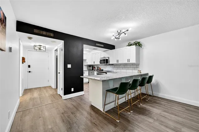 a spacious bathroom with a granite countertop sink a toilet and a mirror