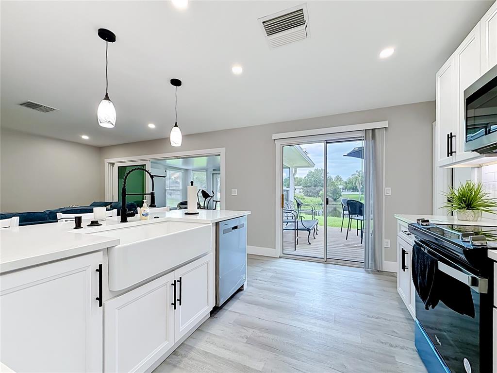 508 Shore Drive Largo, FL 33771 - Photo 9 of 31 a kitchen that has a lot of cabinets stainless steel appliances and wooden floor