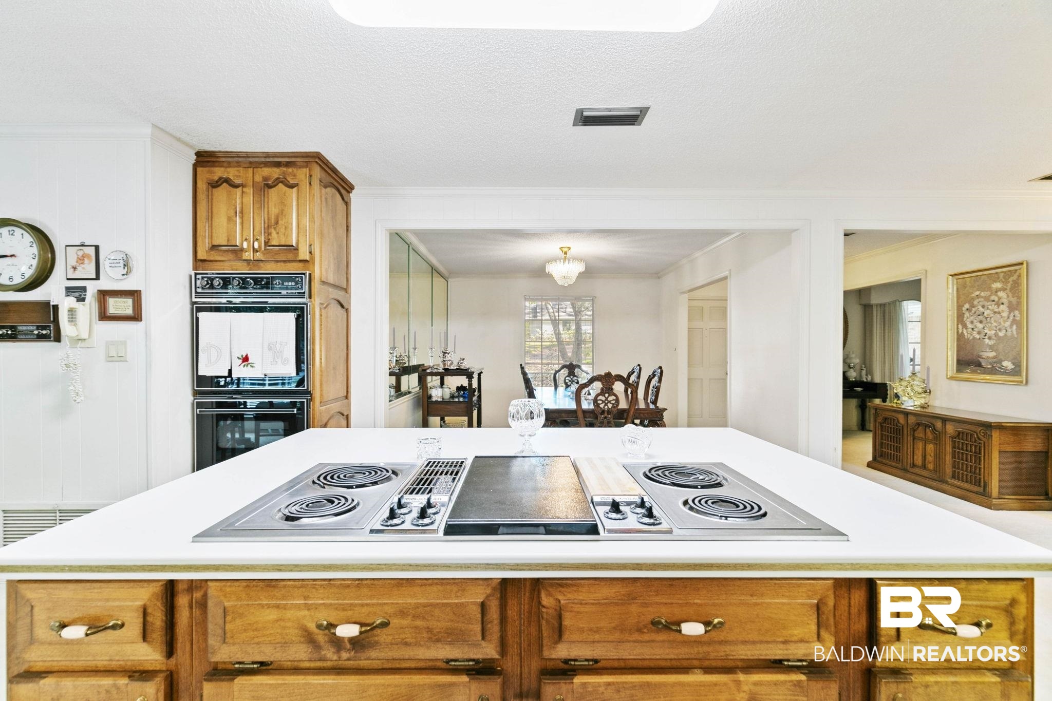752 Evergreen Street Fairhope, AL 36532 - Photo 8 of 100 Kitchen featuring brown cabinets, stainless steel electric stovetop, light countertops, a textured ceiling, and a center island