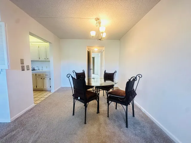 a view of a dining room with furniture and chandelier