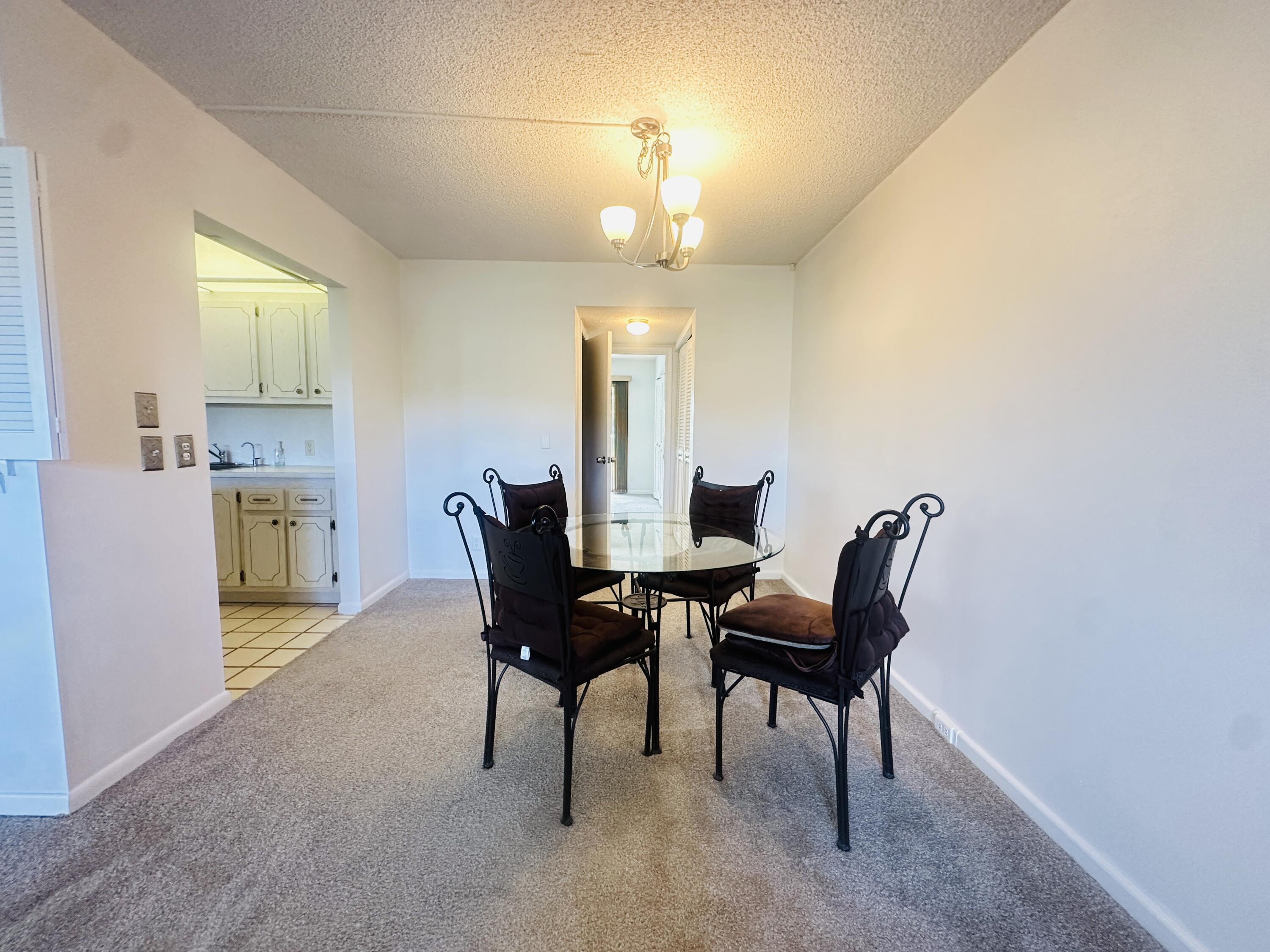 129 Brighton D Boca Raton, FL 33434 - Photo 4 of 11 a view of a dining room with furniture and chandelier