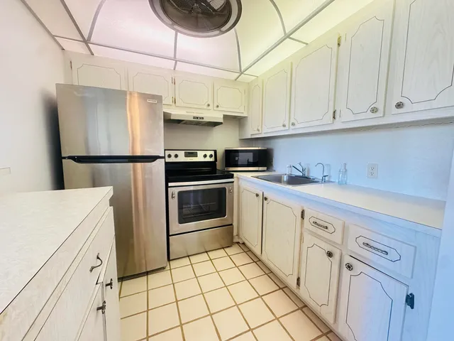 a kitchen with stainless steel appliances granite countertop a refrigerator sink and cabinets