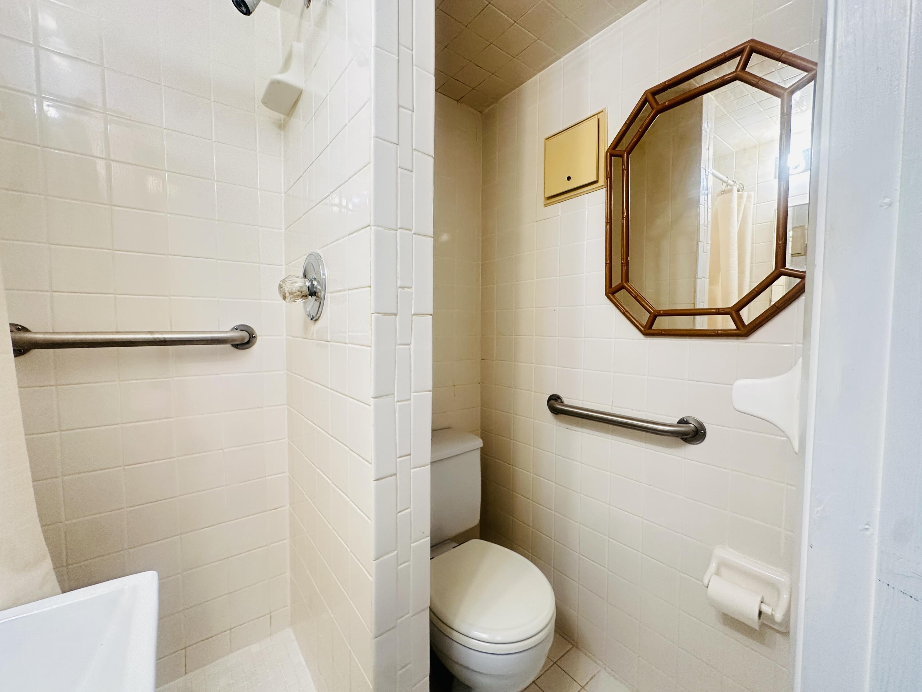 129 Brighton D Boca Raton, FL 33434 - Photo 7 of 11 a bathroom with a toilet and a mirror