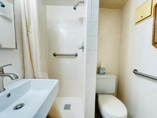 a bathroom with a sink a toilet and shower