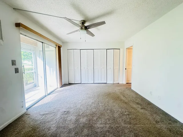 en empty room with windows and fan