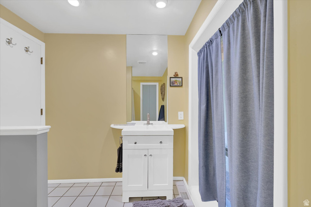 510 Spring Creek Road Providence, UT 84332 - Photo 49 of 97 Bathroom featuring a white vanity with integrated sink, chrome faucet, and mirrored wall