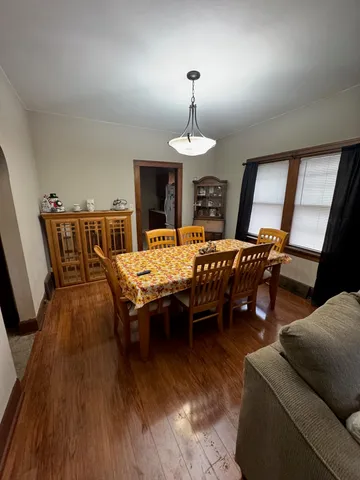 a living room with furniture a chandelier and a wooden floor