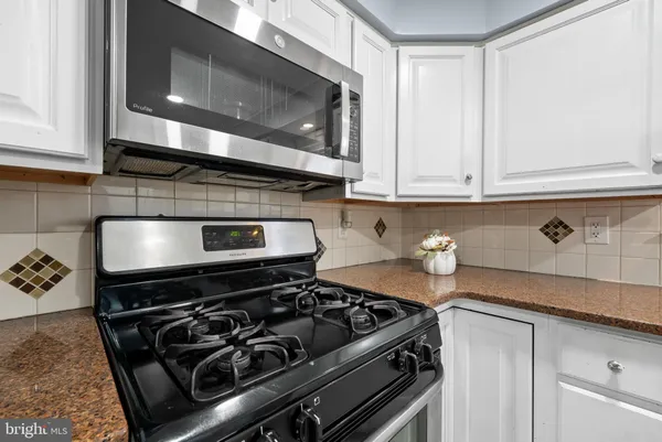a stove top oven sitting inside of a kitchen