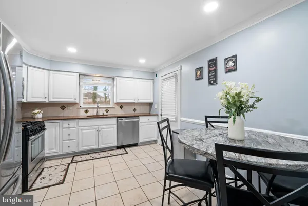 a kitchen with granite countertop white cabinets and stainless steel appliances