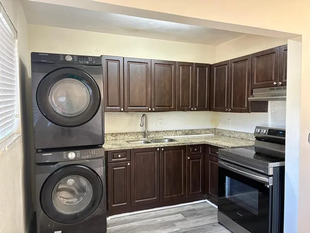 a kitchen with granite countertop a sink and a stove top oven