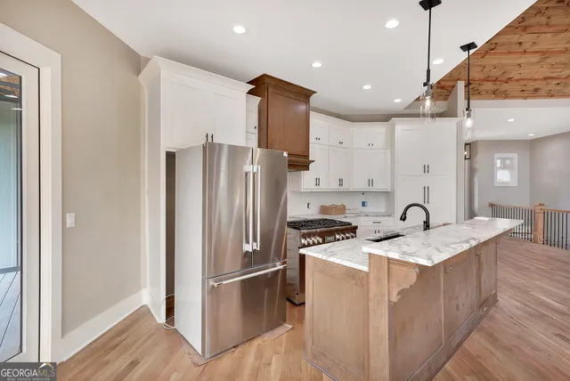 a kitchen with a refrigerator a sink and a stove top oven with wooden floor