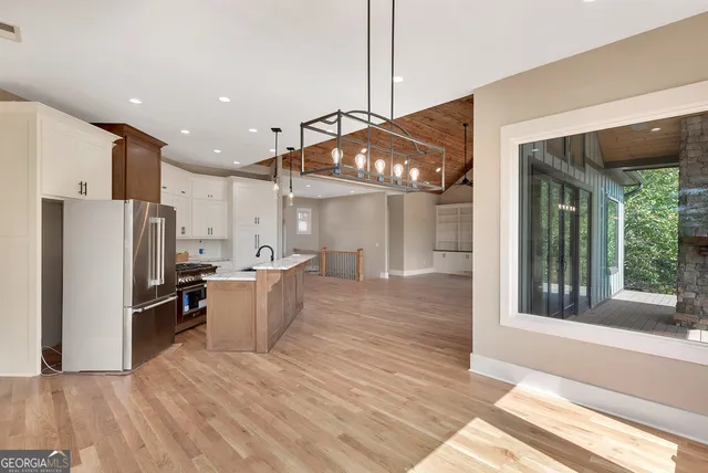 a kitchen with stainless steel appliances kitchen island granite countertop a refrigerator and a stove top oven