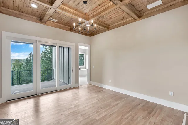en empty room with wooden floor fan and windows