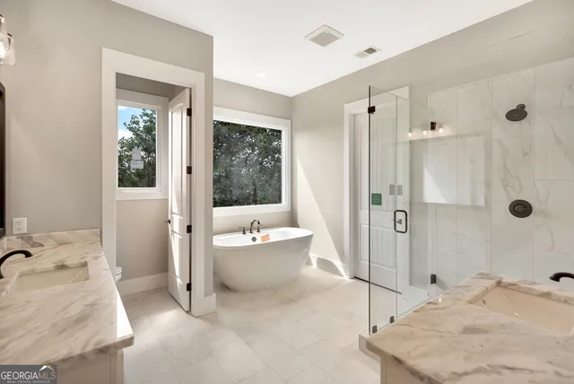 a spacious bathroom with a tub sink and mirror