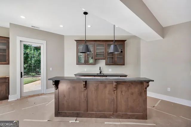 a view of kitchen with stainless steel appliances granite countertop sink and wooden floor