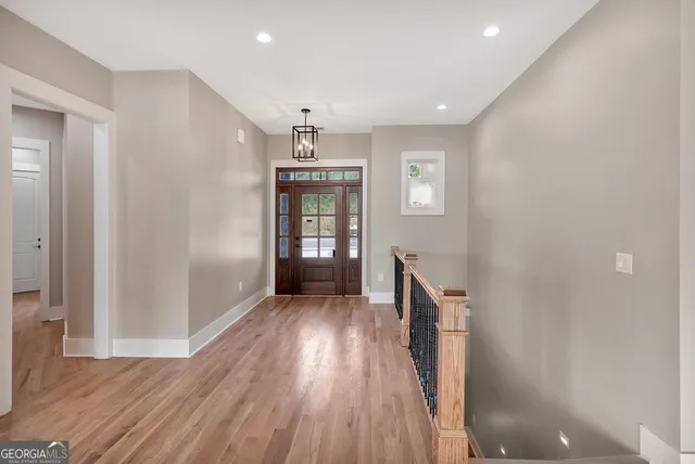 a view of a hallway with wooden floor and staircase