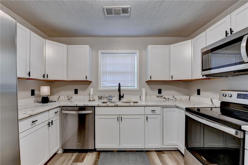 801 Davis Street Monroe, GA 30655 - Photo 11 of 33 a kitchen with stainless steel appliances granite countertop a sink a stove and cabinets