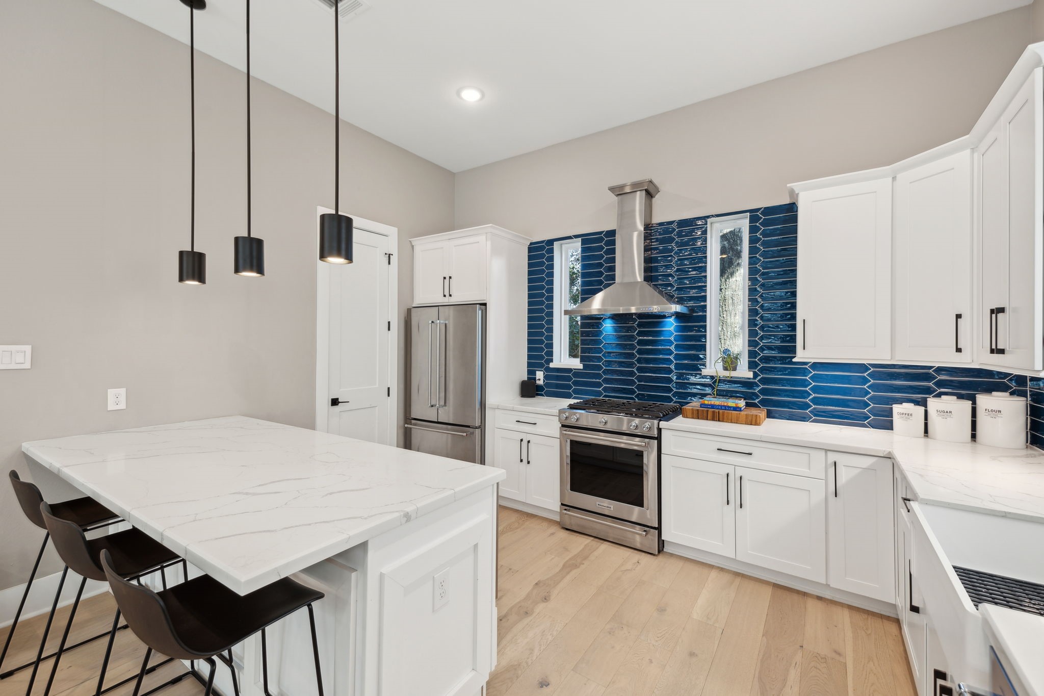 1413 West 23rd Street Houston, TX 77008 - Photo 18 of 39 a kitchen with stainless steel appliances kitchen island a table chairs and a refrigerator