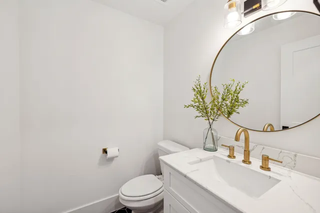 a bathroom with a sink a toilet and a mirror