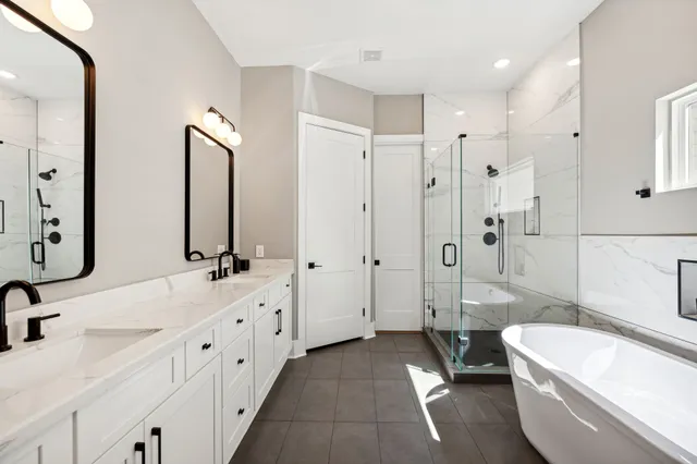 a bathroom with a double vanity sink toilet mirror and bathtub